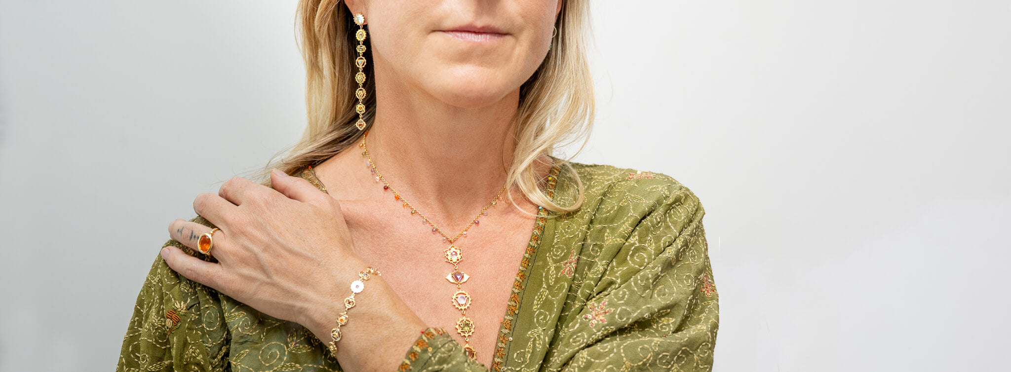 „Frau trägt Karma-Friendly Schmuck mit Edelsteinen der sieben Chakren – heilender Schmuck mit kraftvollen Heil-Edelsteinen für Yoga und spirituelle Balance.“

